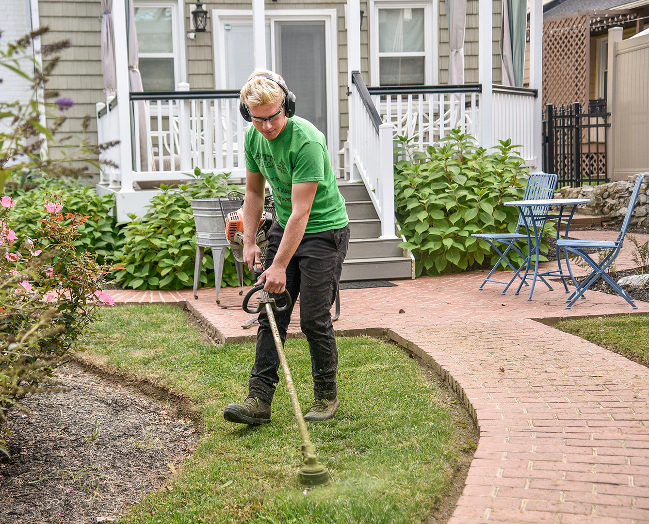 man holding trimmer to trim the lawn